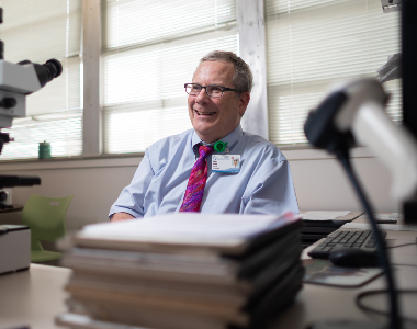 Dr. Brodell smiling behind desk.
